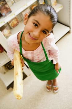 Portrait of a girl holding a baguette and smiling