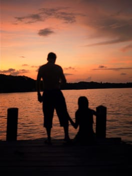Silhouette of a man and a woman on a pier