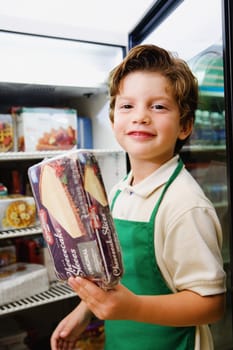 Portrait of a boy holding a box of cake and smiling