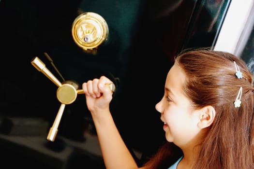 Side profile of a girl holding the handle of a safe