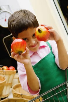 Close-up of a boy showing two pomegranates