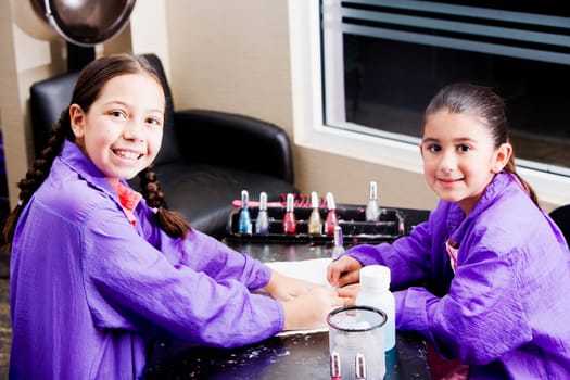 Portrait of a girl giving her sister a manicure