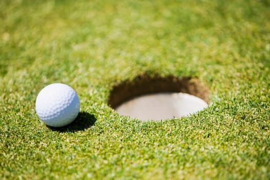 Golf ball at the edge of a hole