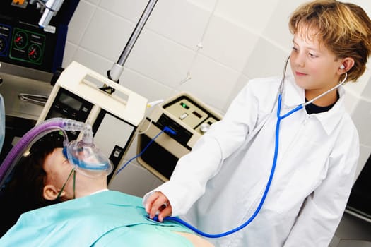 Boy imitating a doctor and examining a patient with a stethoscope