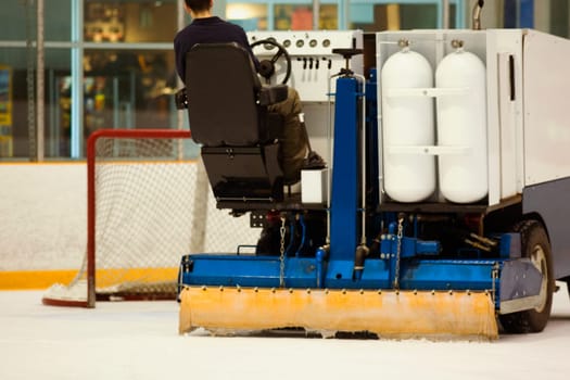 Rear view of a person sitting on an ice resurfacing machine