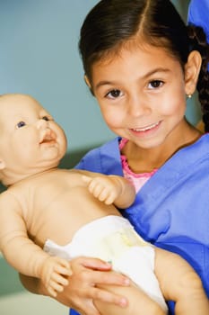 Portrait of a girl carrying a doll and smiling