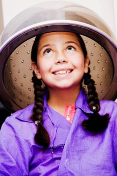 Close-up of a girl sitting under a hair dryer