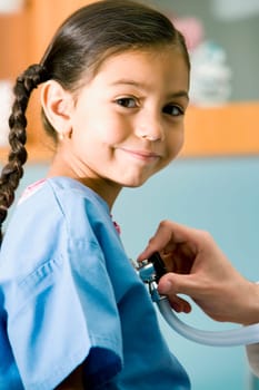 Portrait of a girl smirking while a doctor examining her