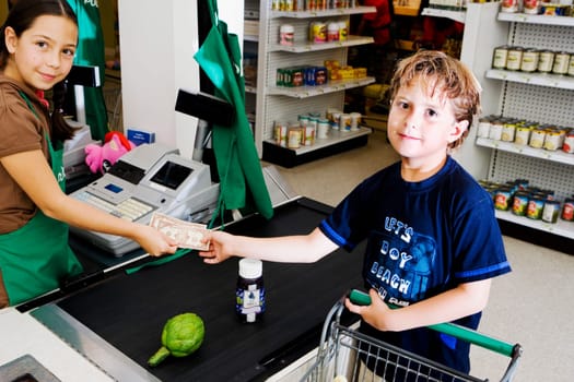 Portrait of a boy giving paper currency to a sales clerk