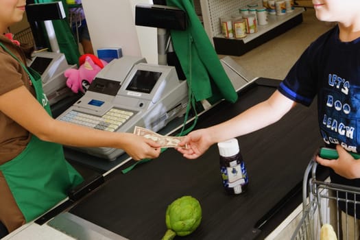 Close-up of a boy paying cash at the checkout counter at a store
