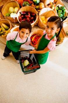 Portrait of a girl holding a shopping basket with a boy smiling