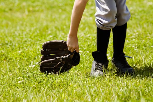 Low section view of a baseball player holding a baseball glove