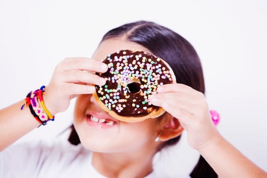 Close-up of a girl holding a donut in front of her eye