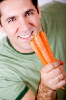Portrait of a mid adult man holding carrots and smiling