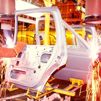 Welder working on car doors in an assembly line, Newark, Delaware, USA