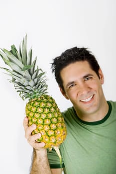 Portrait of a mid adult woman holding a pineapple and smiling