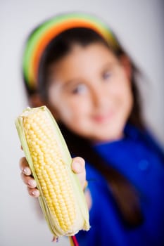 Close-up of a girl showing a corn cob