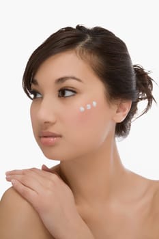 Three dots of moisturizer cream on a womanŽs face