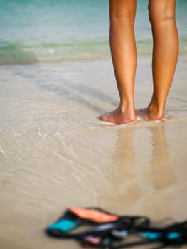 Low section view of a woman standing on the beach