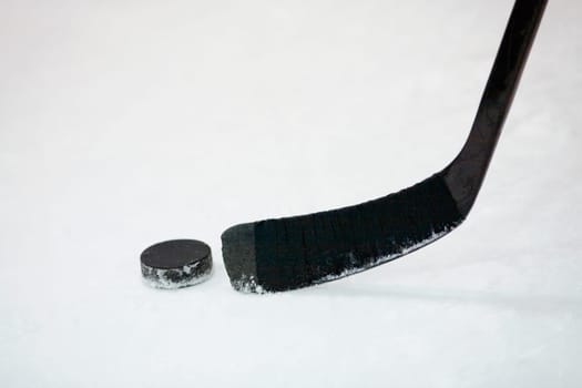 Close-up of an ice hockey stick with a hockey puck