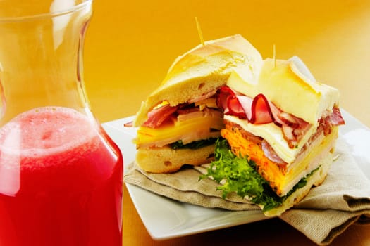 Close-up of roast beef and cheese sandwiches near a bottle of fruit juice