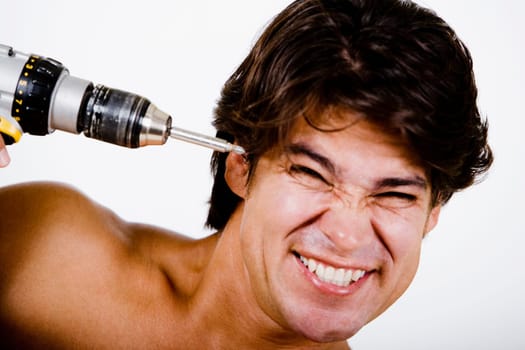 Mid adult man holding a drill machine against his head