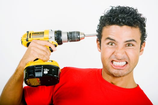 Portrait of a young man holding a drill machine against his head