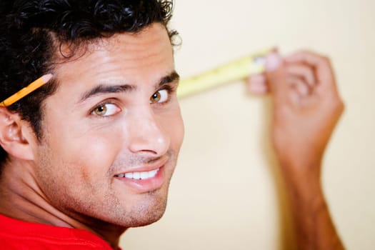 Portrait of a young man measuring with a measuring tape