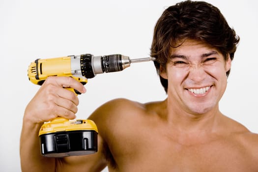 Portrait of a mid adult man holding a drill machine against his head