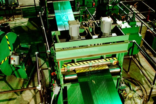 High angle view of stainless steel sheet being rolled in a steel mill