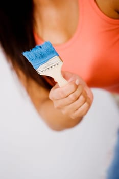 Mid section view of a woman holding a paintbrush