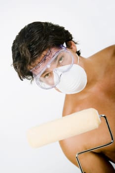 Portrait of a mid adult man wearing a pollution mask with a protective eyewear and holding a paint roller