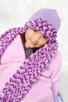 Portrait of a girl sitting in snow and smirking