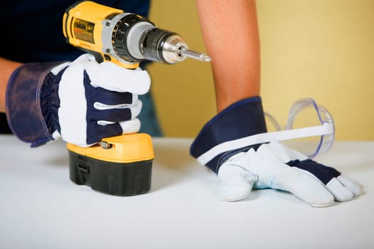 Mid section view of a man holding a drill machine