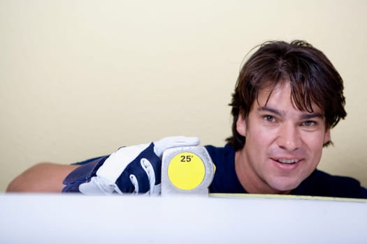 Portrait of a mid adult man measuring with a measuring tape and smiling