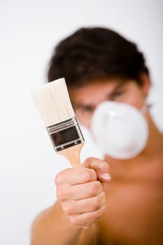 Portrait of a mid adult man wearing a pollution mask and holding a paintbrush