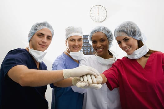 Close-up of surgeons stacking hands on top of each other