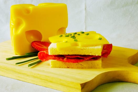 Close-up of a sandwich with slices of cheese on a cutting board