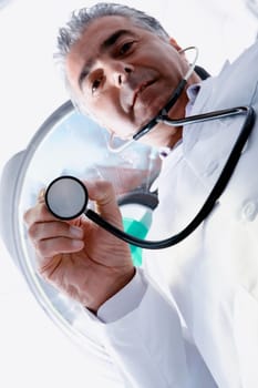 Low angle view of a male doctor holding a stethoscope