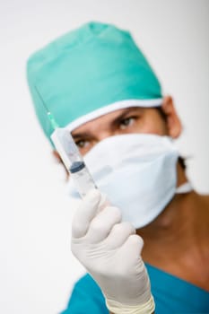 Close-up of a male surgeon holding a syringe