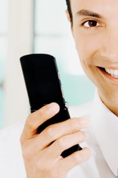 Portrait of a young man holding a mobile phone and smiling