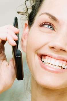 Close-up of a young woman holding a mobile phone and smiling