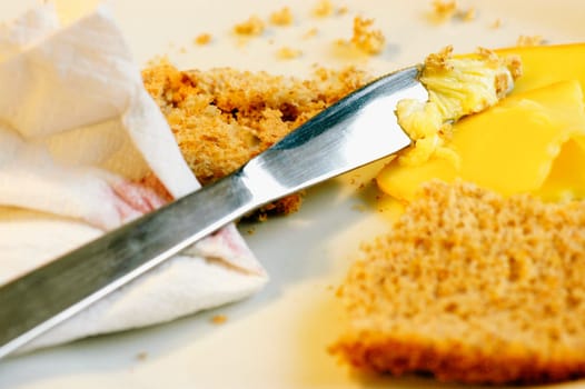 Close-up of a table knife with brown bread and cheese