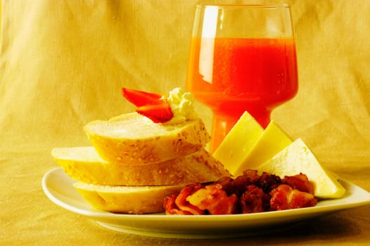 Close-up of slices of bread and cheese with a juice glass on a plate