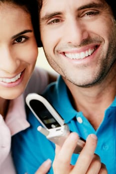 Portrait of a young man holding a mobile phone and smiling with a young woman