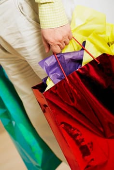 Low section view of a man holding shopping bags