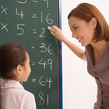 Female teacher teaching her student in a classroom