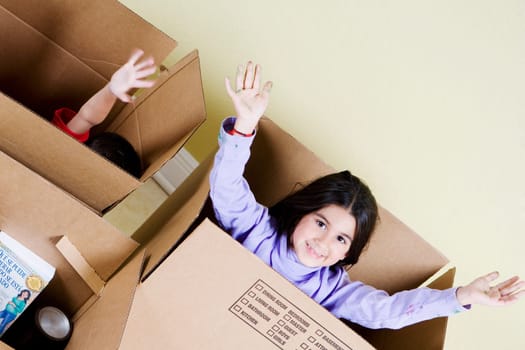 High angle view of a girl and her brother in cardboard boxes