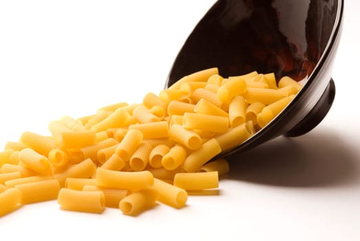 Close_up of a spilled bowl of raw rigatoni pasta