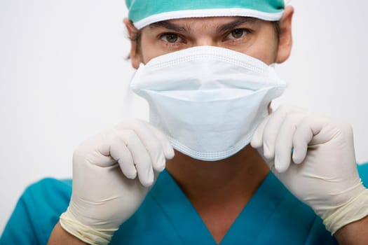 Portrait of a surgeon adjusting a surgical mask
